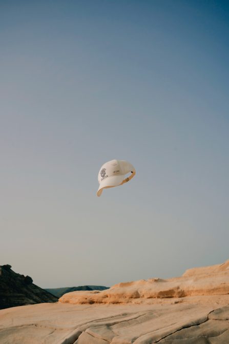 Cream Badlands Collection cap floating in air above desert landscape