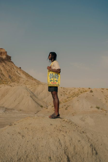 Person standing in desert wearing yellow Badlands Collection tote bag as shirt mockup