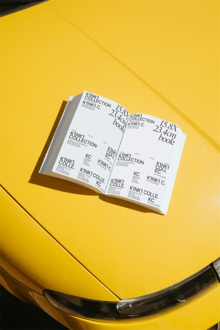 Open book mockup with repeating Kinki Collection branding spread on bright yellow car hood
