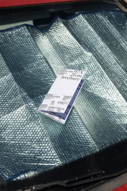 Folded brochure with K1NK1 Collection branding on metallic textured fabric