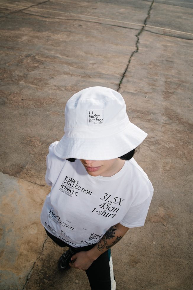 Person in white t-shirt and bucket hat mockup for apparel design showcasing, top down view for urban fashion graphics display.