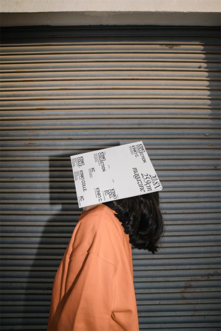 Person with giant ticket mockup covering face against metal shutter, creative presentation, designers marketplace, visual assets.