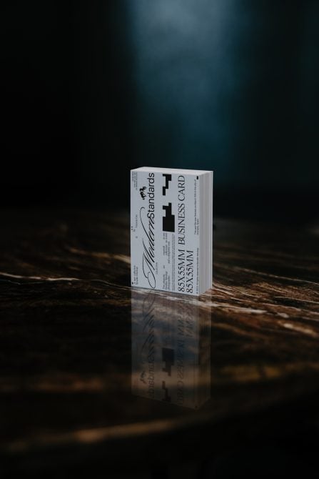 Business card stack mockup on dark wood surface with dramatic lighting