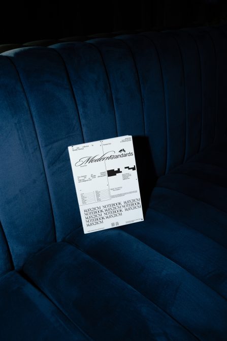 Modern Standards notebook mockup placed on pleated blue velvet chair