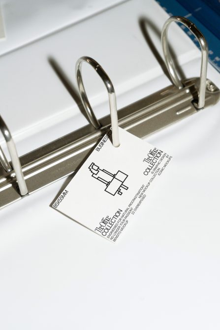 Close-up of a label mockup with a business icon design, attached to a binder ring showcasing product branding potential for designers.