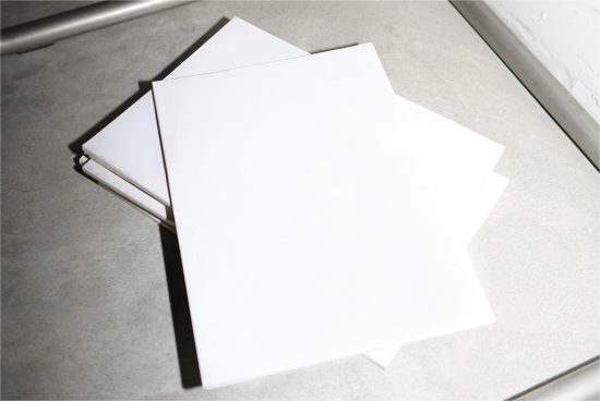 Blank white paper mockup on a concrete background, ideal for presenting letterhead designs, stationery templates, or graphic layouts.