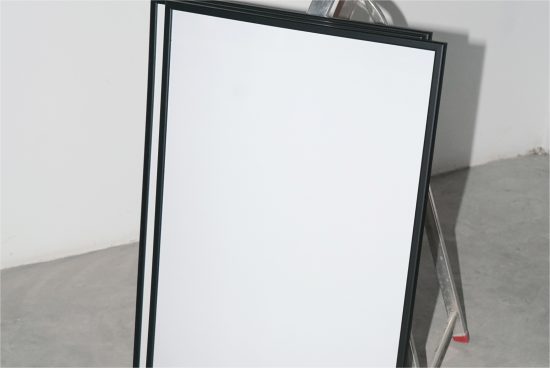 Blank A-frame sidewalk sign mockup standing indoors with a white empty space for graphic design and text.