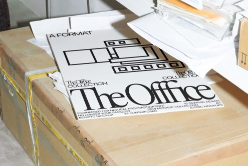 Print mockup sheets with "The Office Collection" text for graphic design projects on a cluttered desk, conveying creativity and workplace realism.