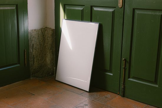 Blank white poster mockup leaning against a green door, vintage building interior, ideal for designers to showcase graphics, templates.