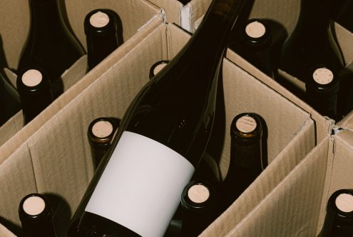 Wine bottles in cardboard box mockup with blank label for branding design, high-quality packaging graphic asset for designers.