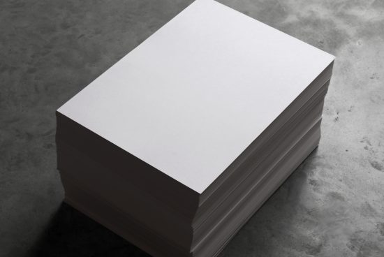 Stack of blank white paper on a textured gray background, ideal for mockup designs, stationery presentation, and graphic elements.
