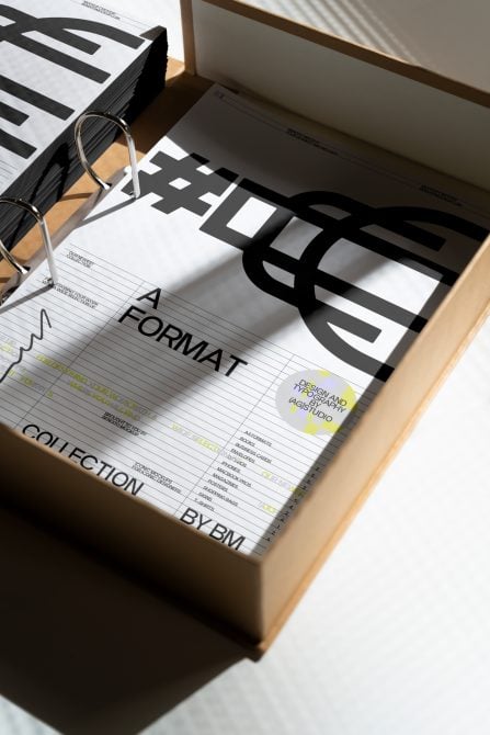 Stacked books in wooden box with wire binding, bold typography, studio lighting