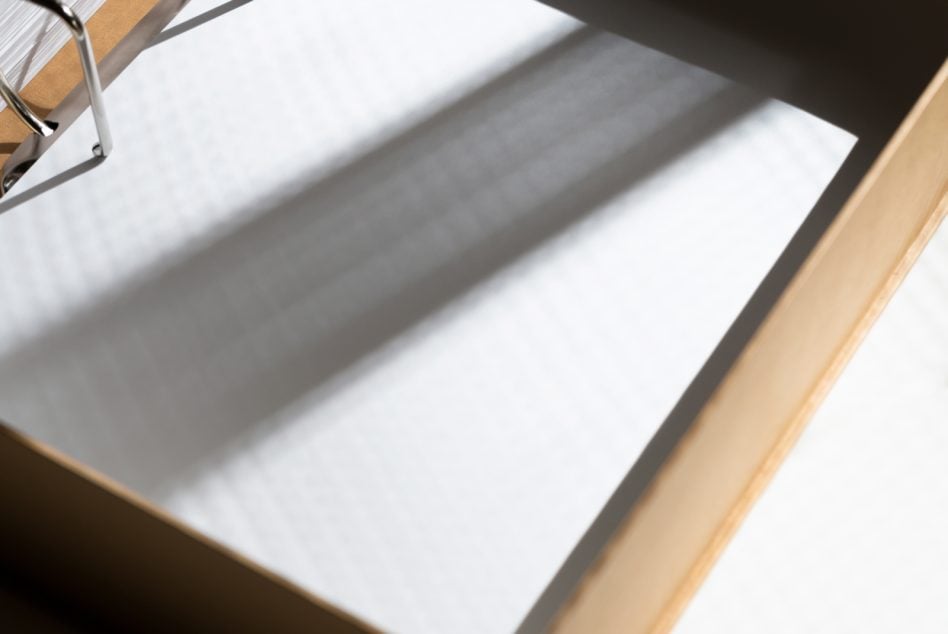 Blank white letterhead in wooden desk tray with natural lighting