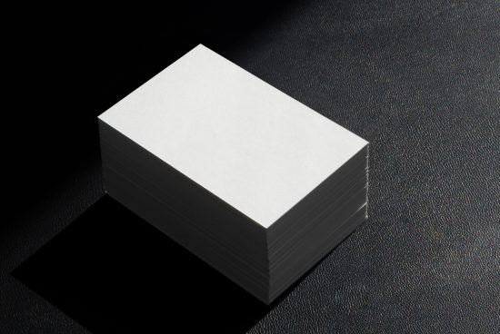 Stack of blank business cards mockup on a textured dark background with natural shadows, ideal for design presentation.