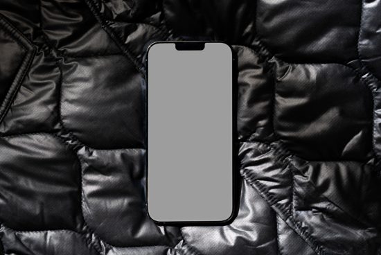 Smartphone mockup on textured black fabric for app design presentation, minimal style, modern mobile display.