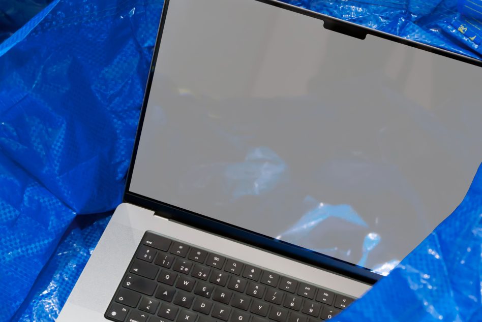 Laptop mockup with blank screen on blue textured surface, ideal for digital design presentations and tech layouts for websites and apps.