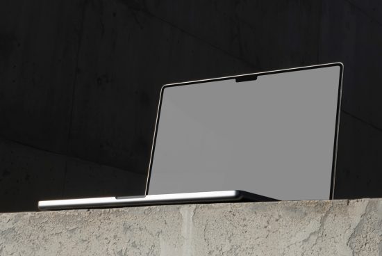 Laptop mockup on concrete ledge, showing screen and keyboard, modern design, ideal for showcasing web and app designs.