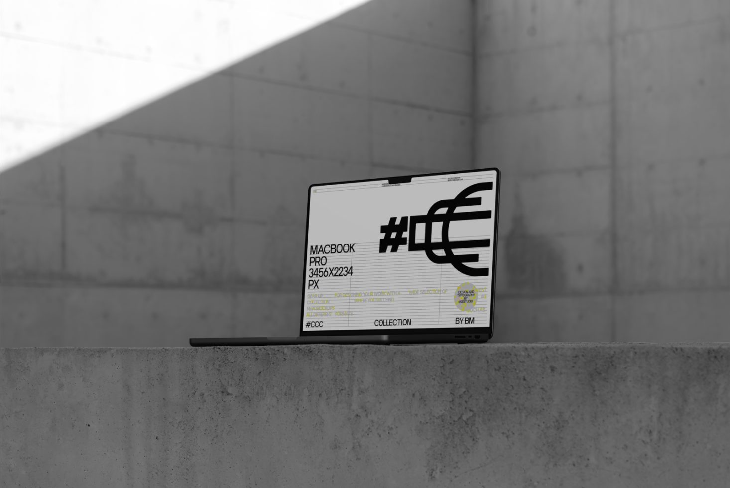 Laptop on concrete with bold graphic design on screen, ideal for mockup presentations, urban setting, designer-oriented visual.