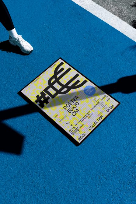 Poster mockup on blue surface with a person's foot in frame, showcasing urban style graphic design for creative market.