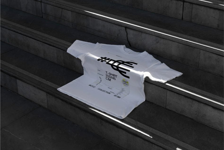 White tshirt with black graphic print lying on dark concrete stairs