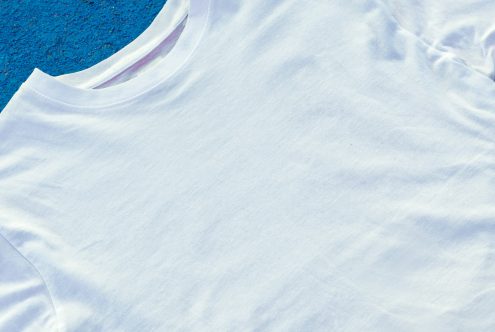 White t-shirt mockup on blue background, high-resolution, clean design, top view, ready for branding and templates.