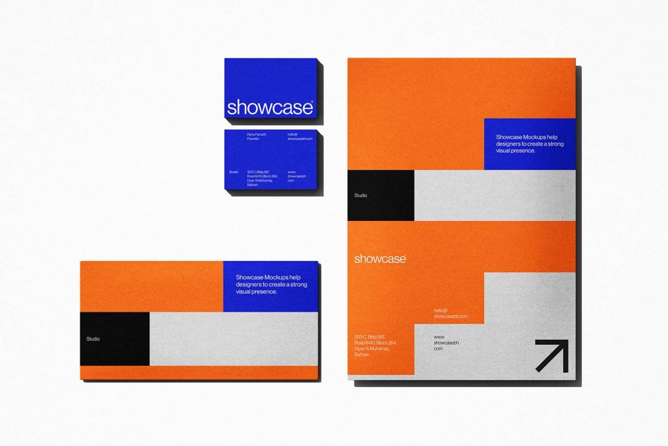 Modern stationery mockup featuring business cards and a booklet with bold orange, grey, and blue designs laid out on a textured surface. Perfect for branding presentations.