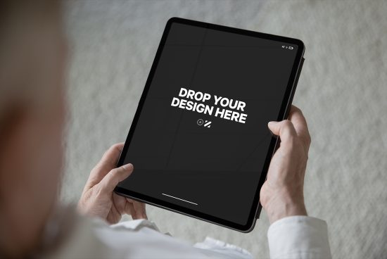 Person holding tablet with placeholder text for designers to mock up their work, focusing on digital presentation in a realistic setting.
