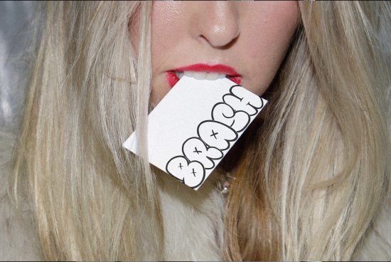 Close-up of a woman with blonde hair holding a speech bubble card with the word CRASH in her mouth, for mockup graphics.