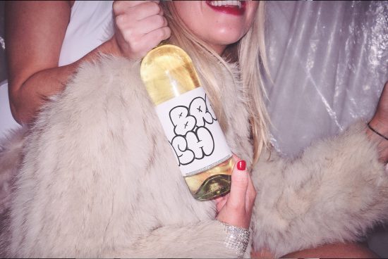 Woman in fur coat holding custom label champagne bottle, celebration theme, design mockup inspiration for graphics and branding.