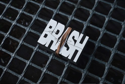 Stack of business cards with bold BRUSH typography on a metal grate background digital assets mockup for designers branding mockups templates graphic design