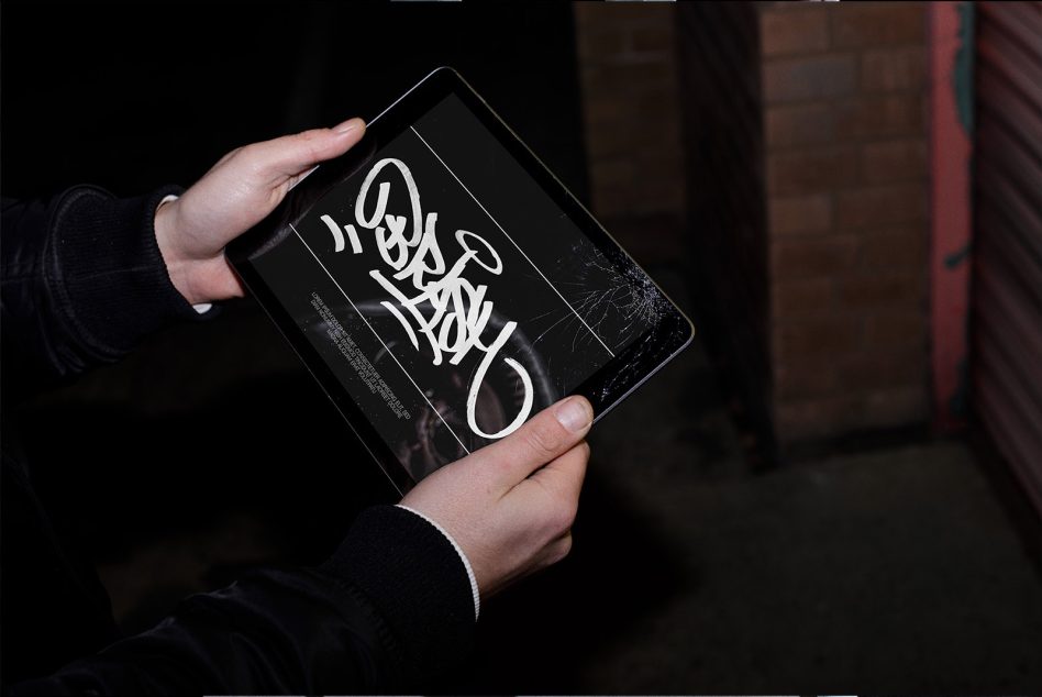 Person holding tablet showcasing graffiti-style font design, ideal for urban graphics and modern typography mockups for creative projects.