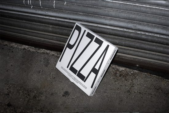Discarded pizza box mockup on urban concrete floor, showcasing bold typography design for impactful branding and packaging presentations.