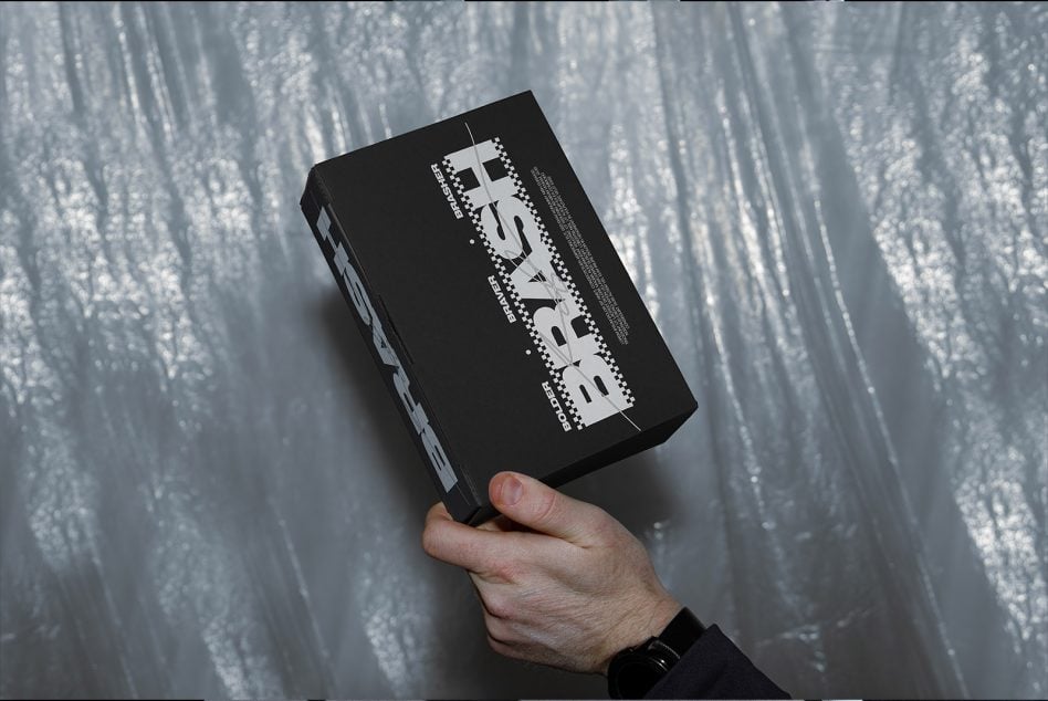 Hand holding black box with white dotted pattern title treatment