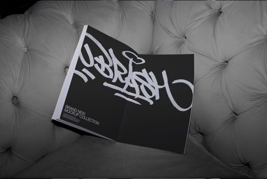 Magazine mockup with graffiti style font on gray sofa, showcasing presentation for print design, portfolio samples, creative assets.