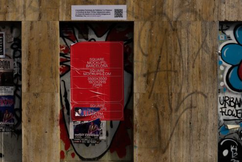 Single red square poster mockup on weathered wood door with graffiti