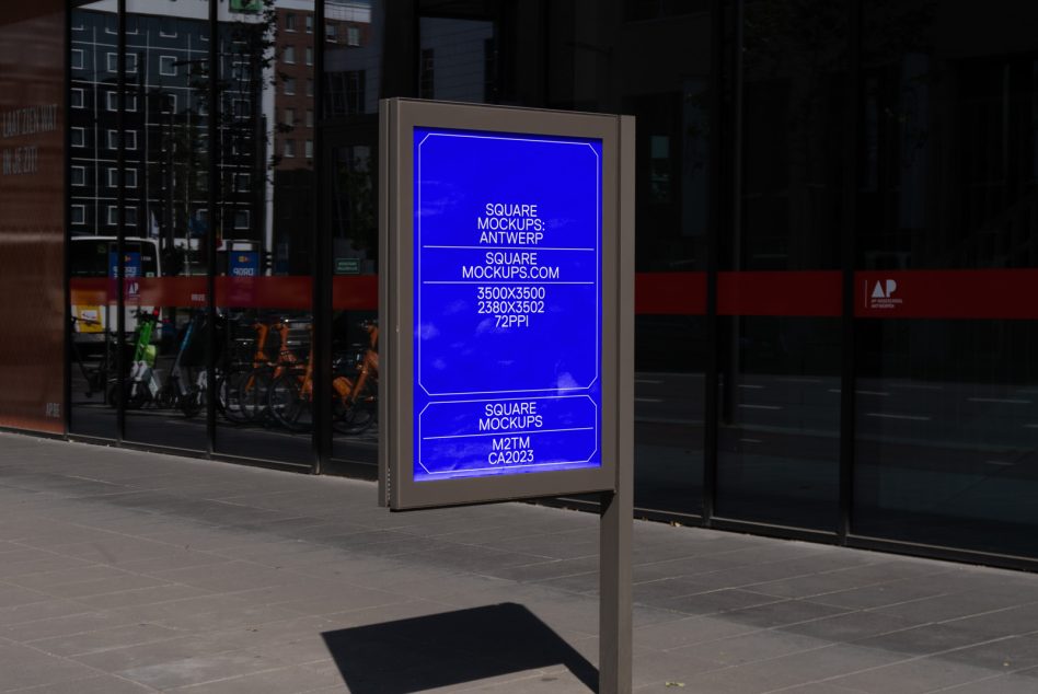 Street-level lightbox sign on tan pole outside storefront, blue neon mockup