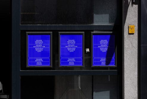 Bright blue neon square mockups glowing in dark storefront, three panels lit up