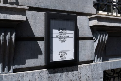 Stone building facade with mounted light box displaying simple white mockup design