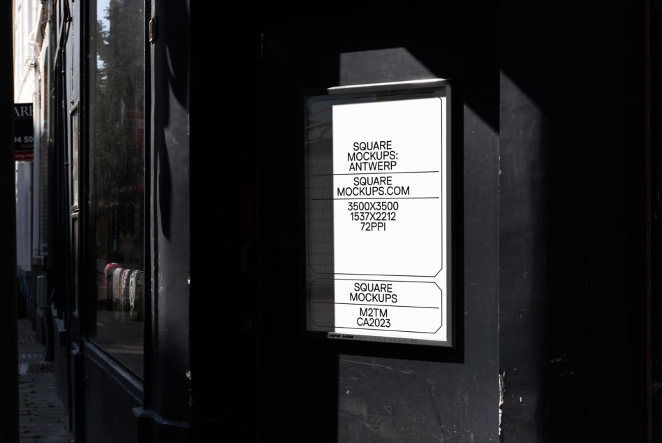 Illuminated window display on dark storefront showing white mockup layout at night