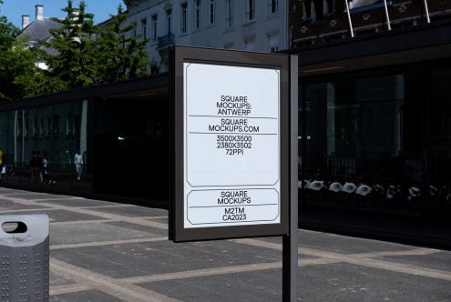 Street-level poster mockup on modern kiosk in sunny outdoor plaza