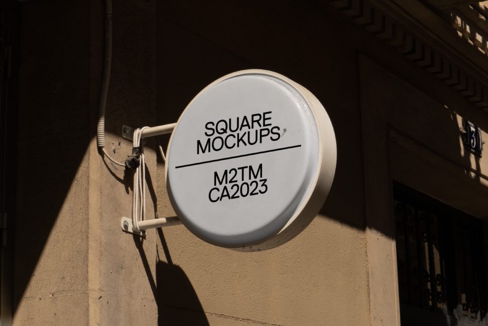 Round white hanging sign in narrow alley with morning sunlight
