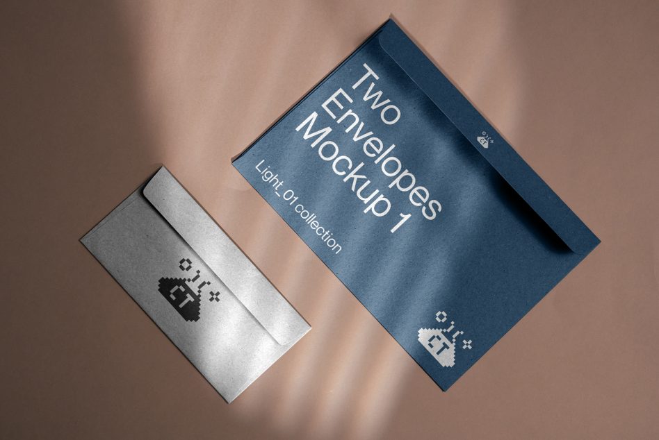 Silver envelope next to blue envelope angled on warm beige background