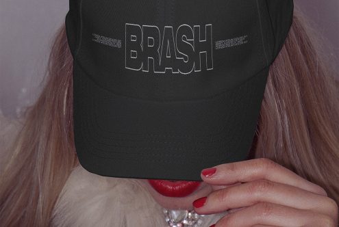 Close-up of a stylish black cap with white text design mockup on a woman, red lipstick, fashion accessory, digital asset for designers.