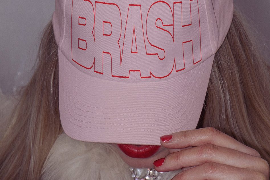 Light pink cap with red outline graffiti lettering held up by person