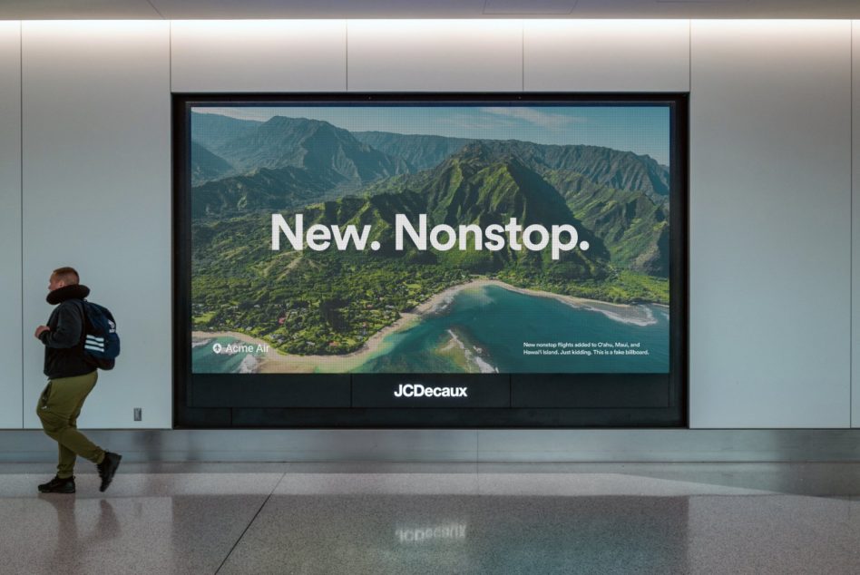 Large airport billboard displaying tropical island landscape with New. Nonstop. headline