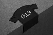 Black tee folded flat displaying white 'ØT3' print from above view