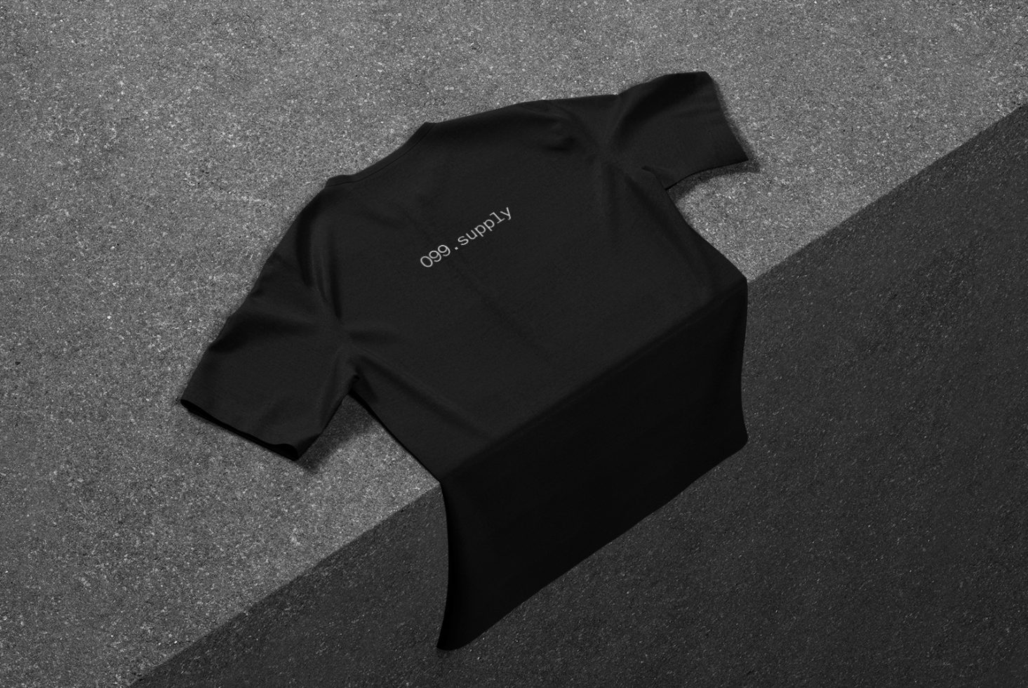 Black t-shirt mockup on textured background for apparel design presentation, showcasing minimal branding.