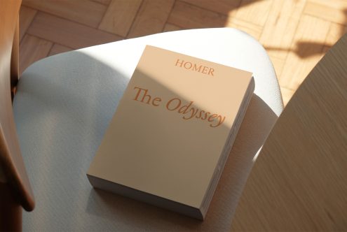 Elegant book cover mockup for "The Odyssey" by Homer on chair with natural light casting shadow, perfect for showcasing design work to clients.