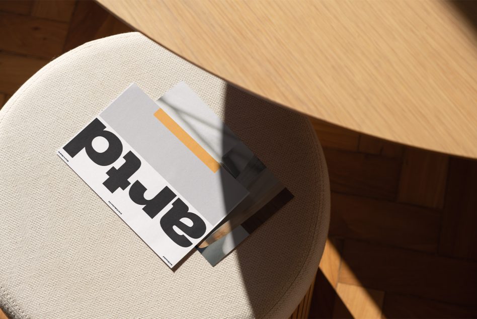 Magazine on textured chair surface showing offset shadow with orange detail stripe