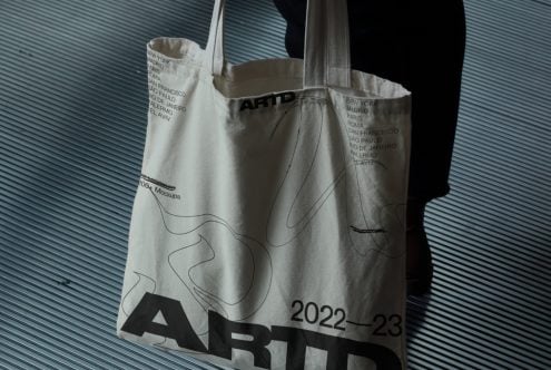 Canvas tote bag showing ARTD branding with city names printed on cream fabric